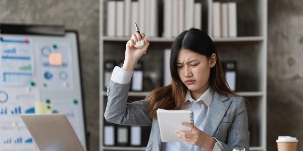 Stressed Asian business woman worry about marketing plan of this years. Account, Real Estate Agent