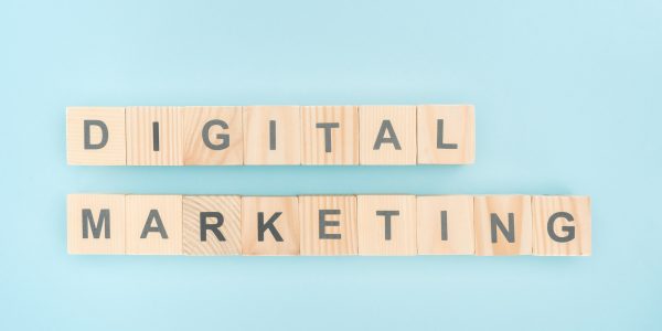 top view of digital marketing lettering made of wooden cubes on blue background